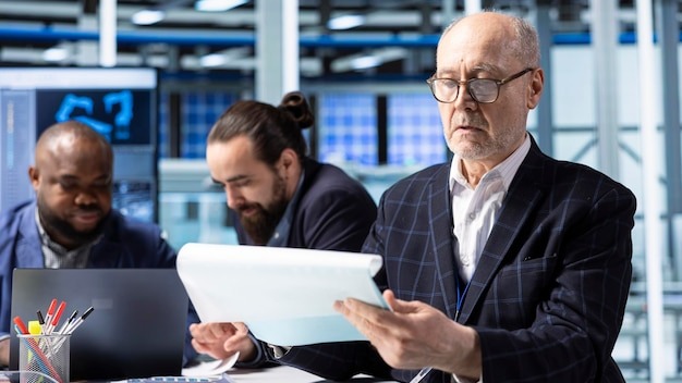 Senior industrial plant shareholder looking at documents analyzing revenue