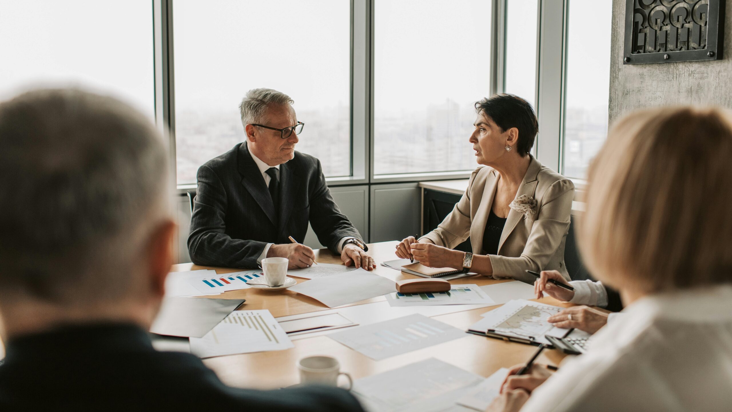 Business professionals engaged in a strategic meeting in a modern office setting with natural light.